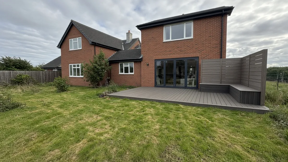 Example image: composite deck with a corner windbreak behind a new detached house